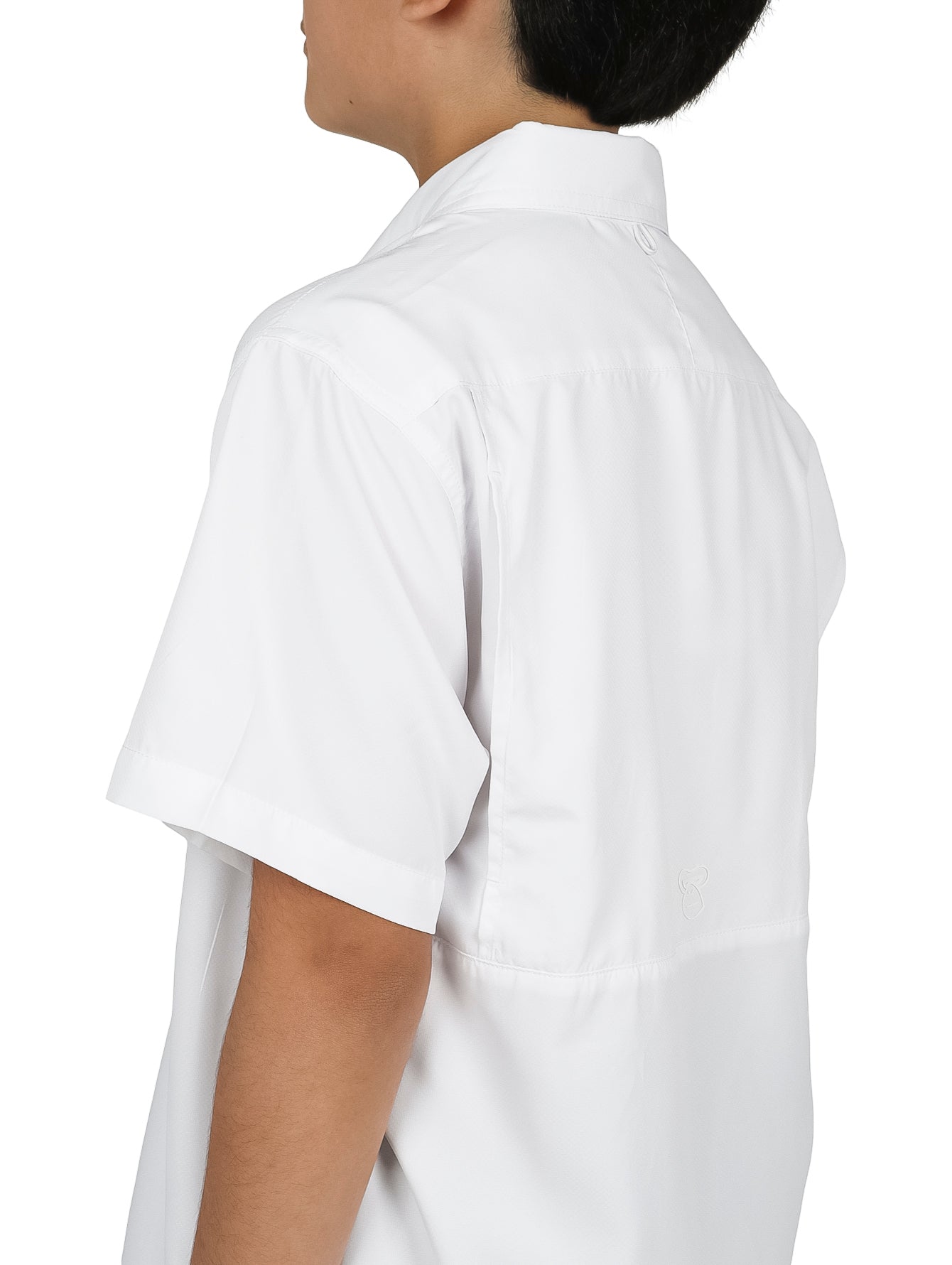 Niño modelando una camisa blanca de manga corta con bolsillos y pantalones cargo color verde oliva.