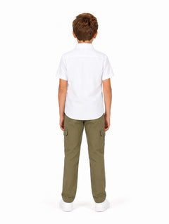 Niño modelando una camisa blanca de manga corta con bolsillos y pantalones cargo color verde oliva.