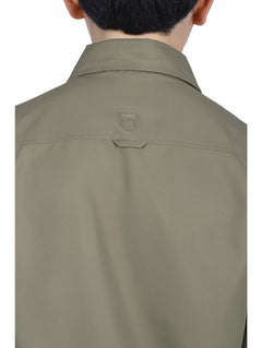 Niño vistiendo camisa de manga larga color verde militar y pantalones beige sobre fondo blanco.