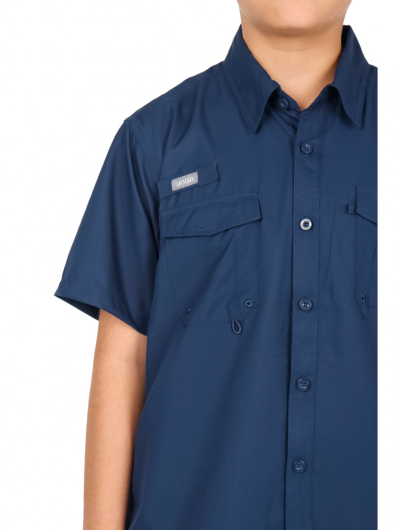 Niño vistiendo una camisa casual color navy de manga corta con bolsillos frontales y pantalones negros.