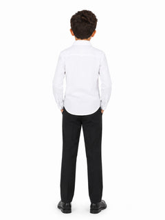 Niño vistiendo una camisa blanca de manga larga y pantalones negros sobre fondo blanco.