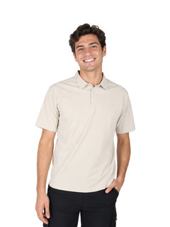Hombre vistiendo una playera polo color beige de manga corta y pantalones negros.