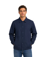 Hombre vistiendo una camisa azul marino de manga larga con botones de presión y cuello.