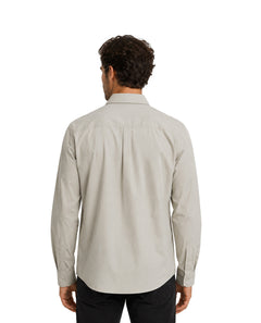 Hombre vistiendo una camisa de manga larga color gris claro con cuello y un bolsillo en el pecho.