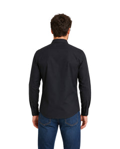 Hombre vistiendo una camisa negra de manga larga y pantalones vaqueros azules.