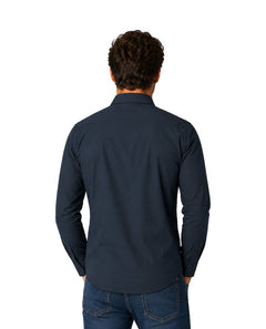 Hombre vistiendo una camisa de manga larga color azul marino y pantalones de mezclilla.